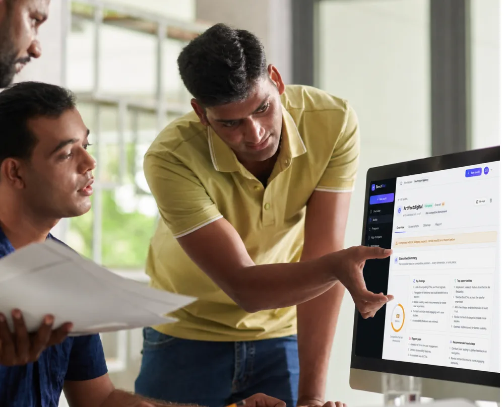 Two people reviewing a site audit report together on a desktop screen.