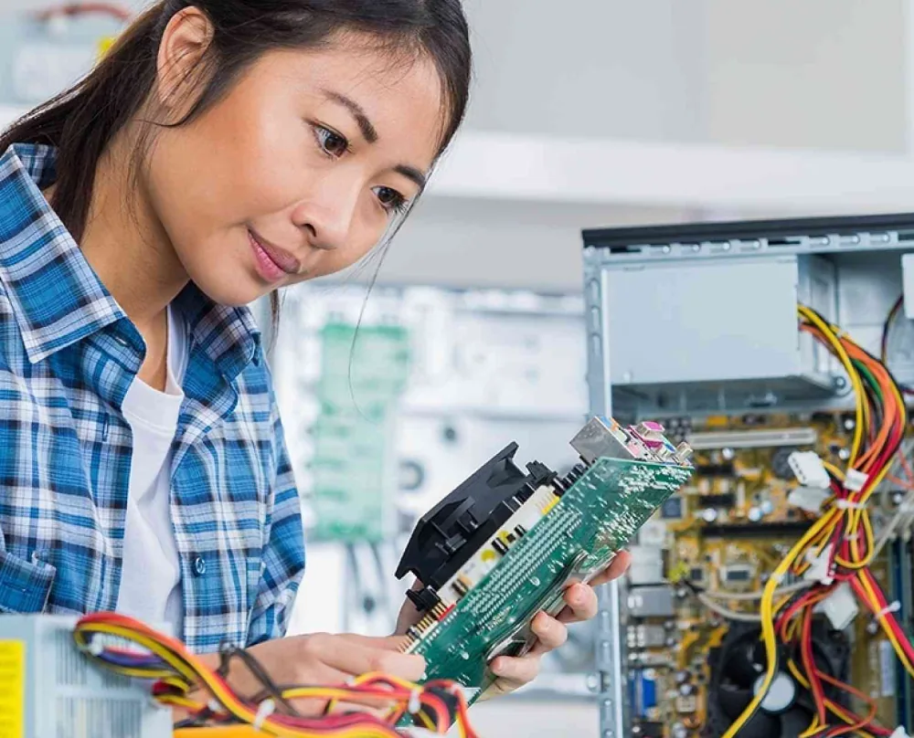 A student working hands-on with computer hardware during a certification course.